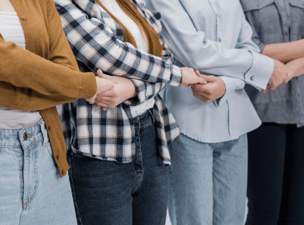 Mujeres unidas de la mano simbolizando igualdad y apoyo mutuo en municipios 2025