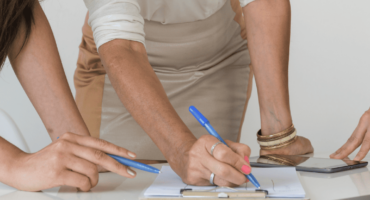 Personas revisando y firmando documentación relacionada con el plan de igualdad en una empresa